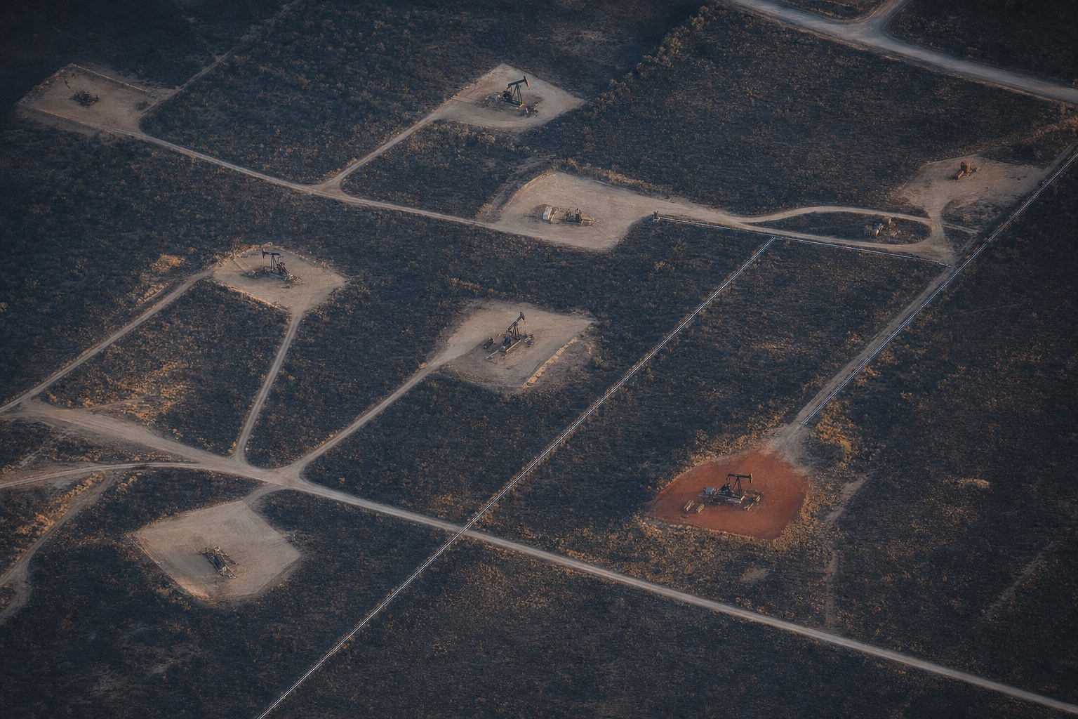 Aerial view of pumpjacks and lease roads across a West Texas oil field